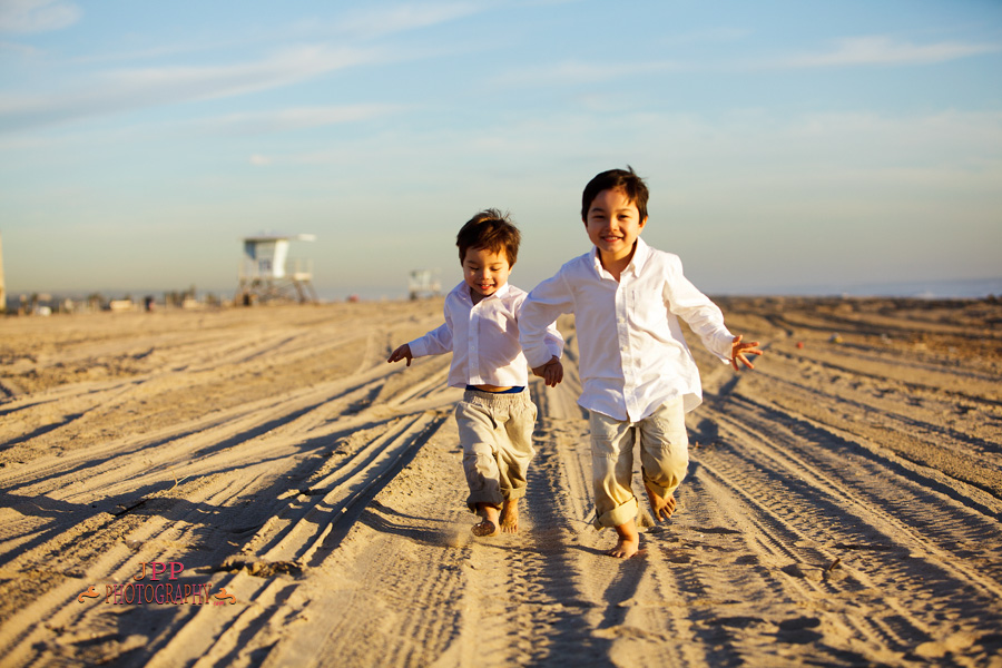 Sibling brothers running on the beach portrait